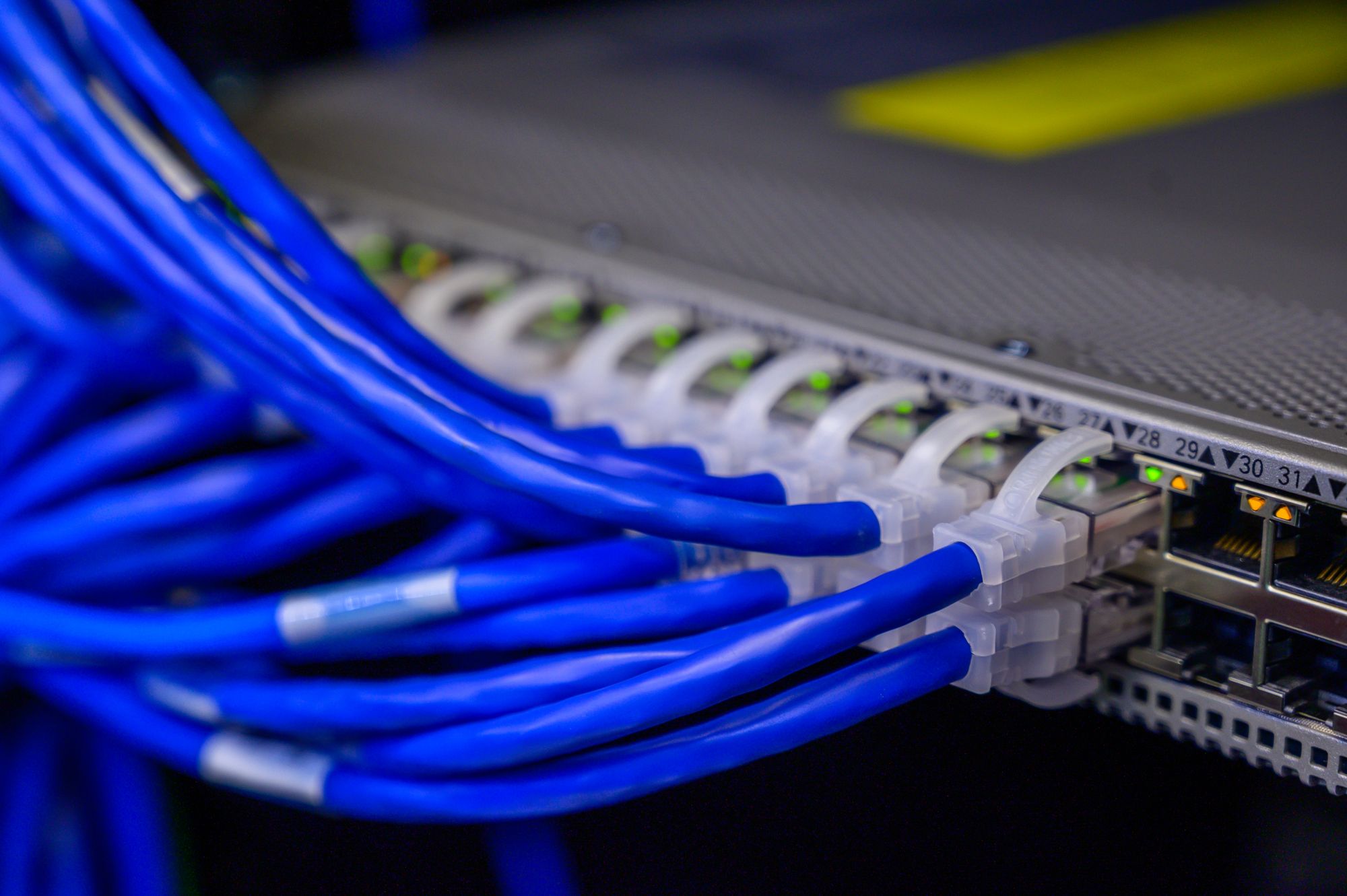 Ethernet patch cables terminated into the front ports of a managed rack switch
